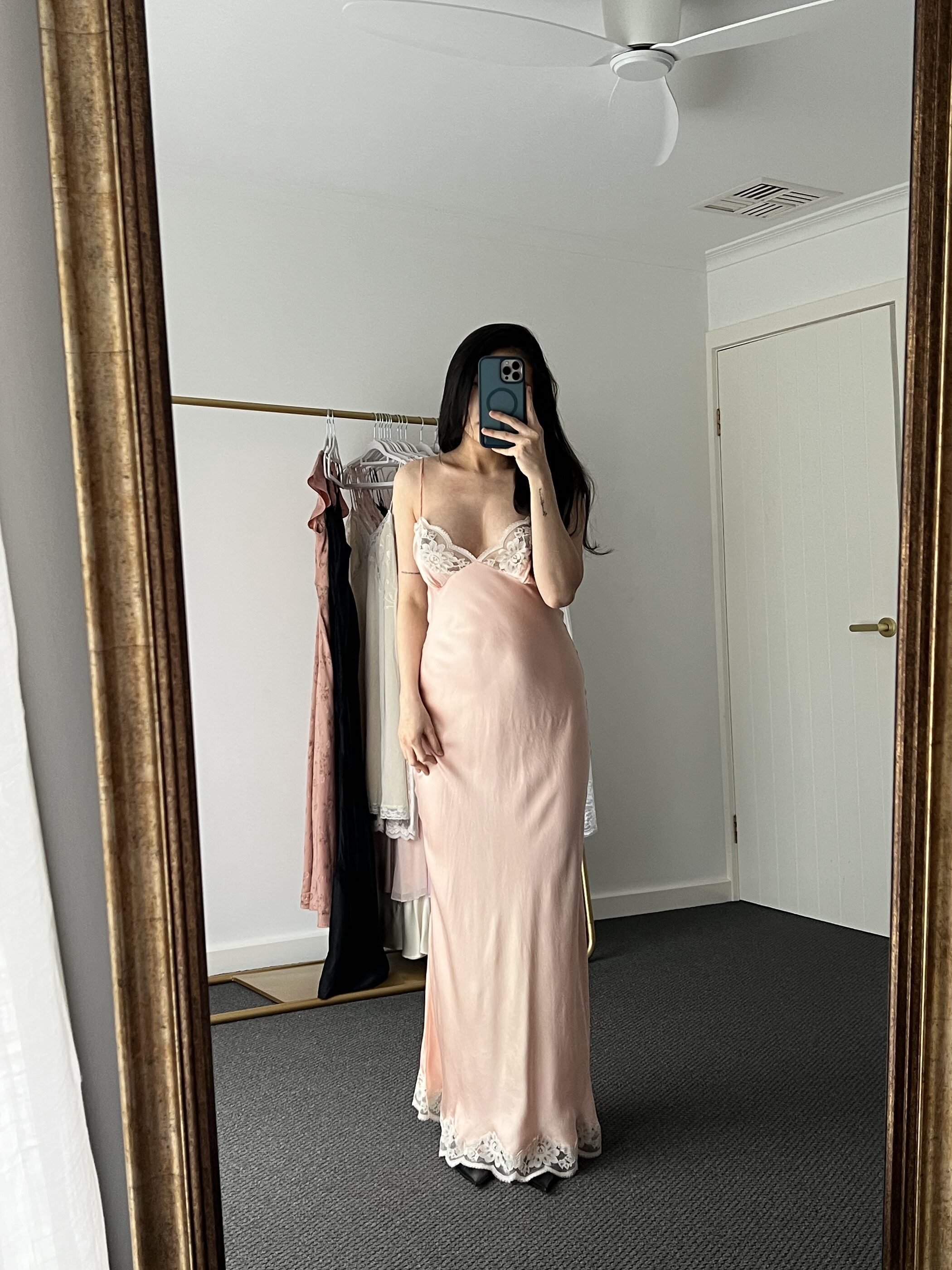 The gown full length in the mirror, the lace hem just meeting the floor