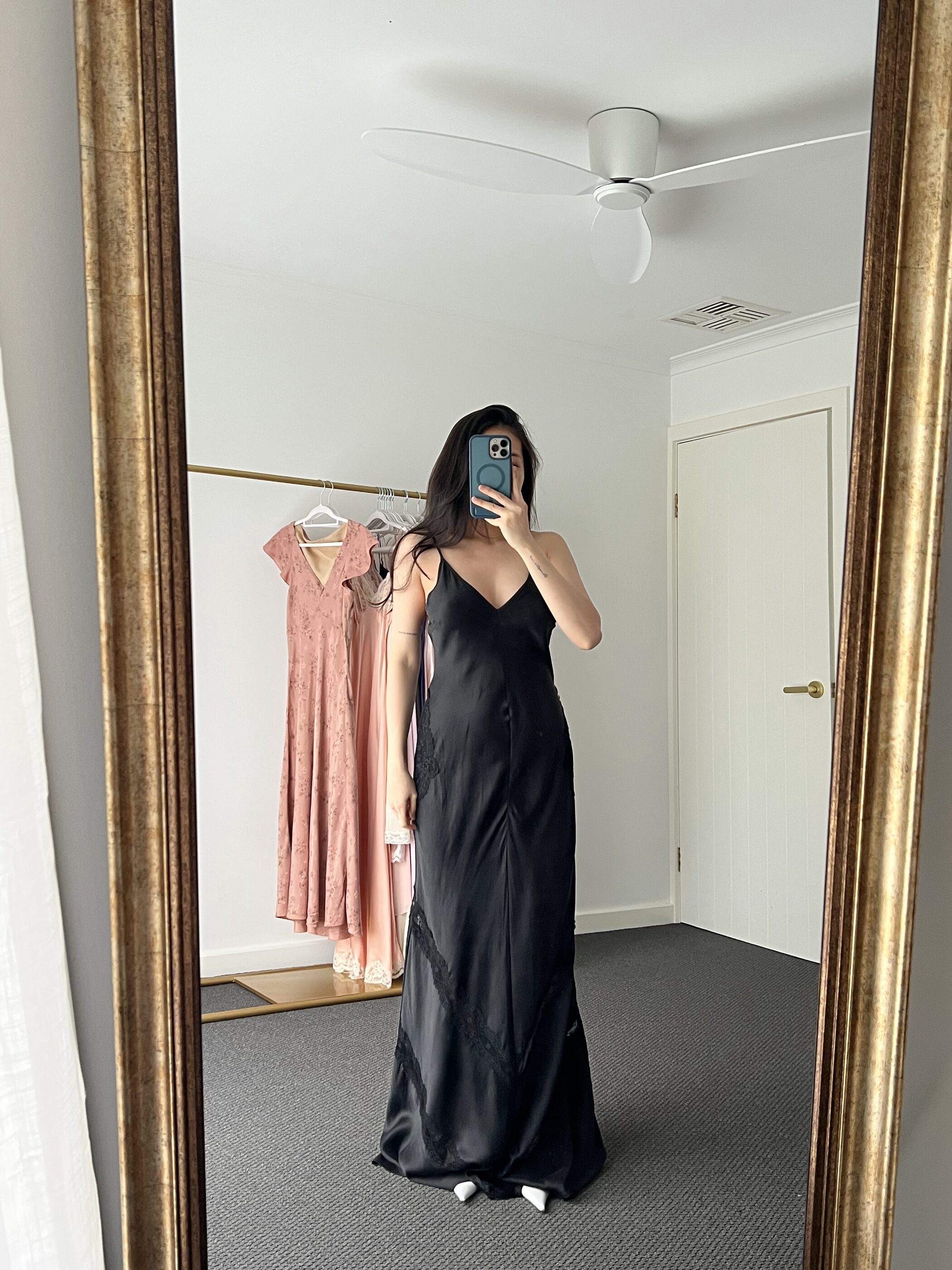 Black bias-cut silk slip gown, worn, seen in a gilt mirror