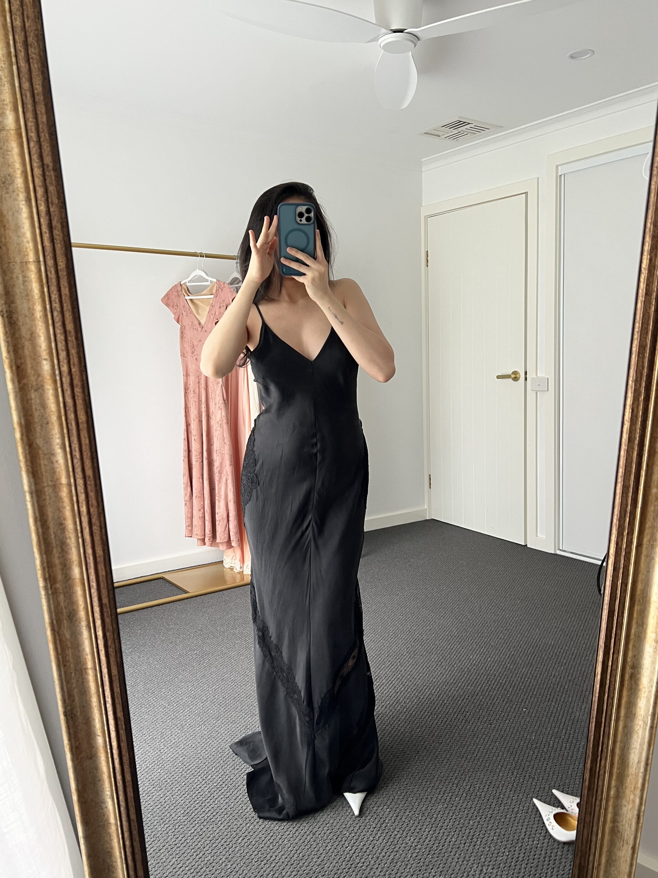 The black gown full length, pooling slightly at the hem